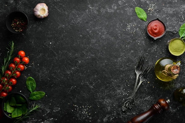 Black cooking background. Vegetables and spices on the table. Top view. Free space for your text.