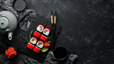 Suşi rulo - Tobiko havyarlı ve somonlu kırmızı ejderha. Geleneksel Japon mutfağı. Üst görünüm.