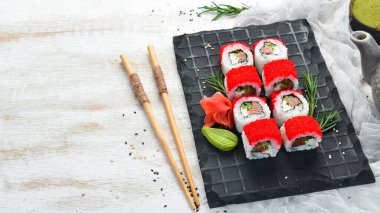 Suşi rulo - Tobiko havyarlı ve somonlu kırmızı ejderha. Geleneksel Japon mutfağı. Üst görünüm.