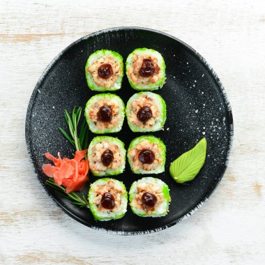 Yeşil suşi rulo - yılan balığı ve yeşil Tobiko havyarlı. Lezzetli suşi parçaları. Üst görünüm.