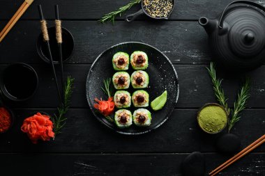 Yeşil suşi rulo - yılan balığı ve yeşil Tobiko havyarlı. Lezzetli suşi parçaları. Üst görünüm.