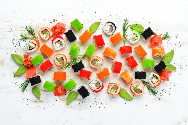 Sushi set on white wooden background. Set of colored sushi with seafood. Traditional Japanese cuisine.