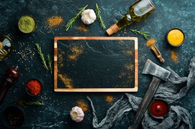 Siyah taş pişirme afişi. Baharatlar ve bitkiler. Üst görünüm.