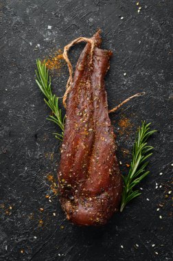 Biberiye ve baharatlı kurutulmuş tavuk göğsü. Tavuk eti. Siyah taştan bir arka planda. Üst görünüm.