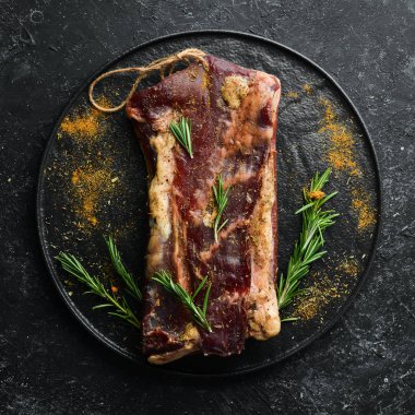 Biberiye ve baharatlı kurutulmuş tuzlu et. Jamon. Siyah taştan bir arka planda. Üst görünüm.