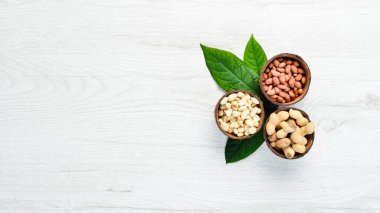 Fıstıklar beyaz ahşap arka planda kaselerde. Ceviz arkaplan. Üst görünüm.