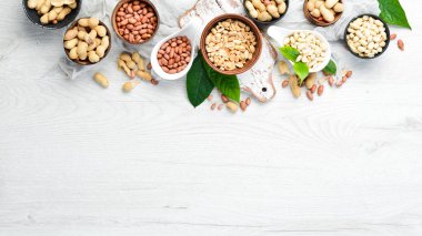 Fıstıklar beyaz ahşap arka planda kaselerde. Ceviz arkaplan. Üst görünüm.