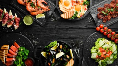 Siyah arka planda et, balık ve salata seti. Üst Manzara. Sağlıklı yiyecek çeşitleri.