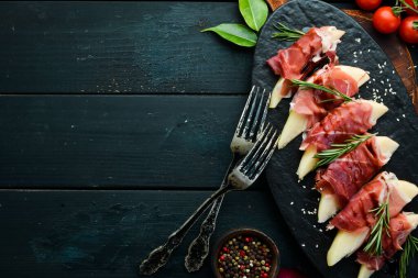 İtalyan yemeği. Armut ve balzamik soslu jambon. Jamon siyah taştan bir tabakta. Üst görünüm.