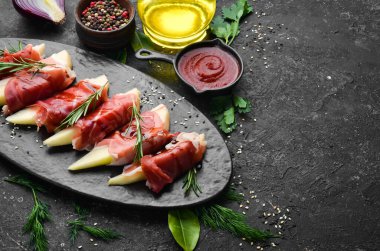 İtalyan yemeği. Armut ve balzamik soslu jambon. Jamon siyah taştan bir tabakta. Üst görünüm.