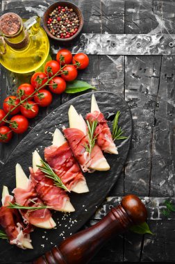 İtalyan yemeği. Armut ve balzamik soslu jambon. Jamon siyah taştan bir tabakta. Üst görünüm.