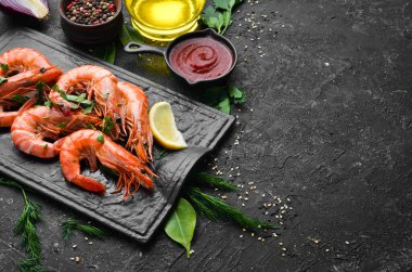 Siyah taş tabakta maydanozlu ve limonlu haşlanmış karides. Üst Manzara. Deniz ürünleri..