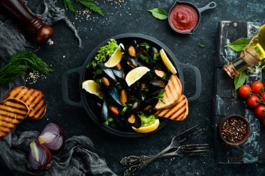 Kızartma tavasında haşlanmış midye, maydanoz ve limon. Üst Manzara. Metnin için boş yer.