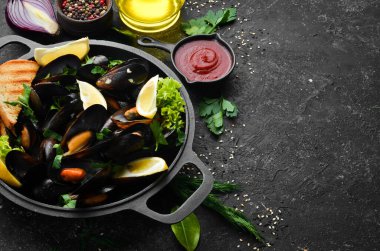 Kızartma tavasında haşlanmış midye, maydanoz ve limon. Üst Manzara. Metnin için boş yer.