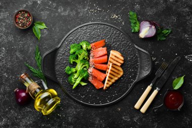 Brokoli ve tuzlanmış somon balığı. Sağlıklı Diyet Yemekleri. Siyah taştan bir tabakta. Üst görünüm.