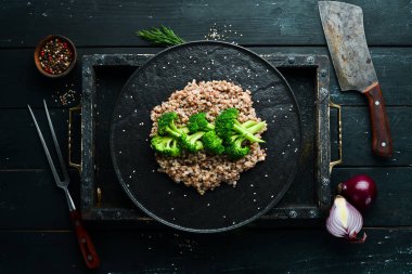Sağlıklı Diyet Yemekleri. Haşlanmış karabuğday ve brokoli. Siyah taştan bir tabakta. Üst görünüm.