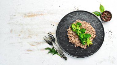 Sağlıklı Diyet Yemekleri. Haşlanmış karabuğday ve brokoli. Siyah taştan bir tabakta. Üst görünüm.