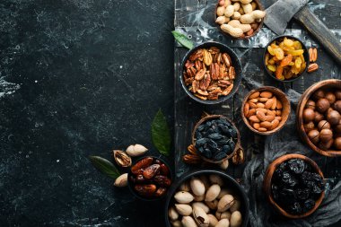 Siyah bir arka planda fındık ve kurutulmuş meyve ve dut seti. Üst Manzara. Metnin için boş yer.
