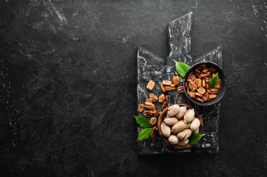 Siyah taş arka planda fındık. Ceviz çeşitleri. Üst bölüm. Metnin için boş yer.