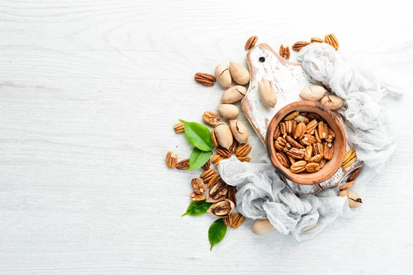 Delicious Pecan nuts on white background Wooden. Top view. Free space for your text.