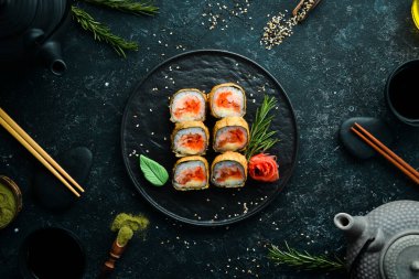 Ton balığı ve havyarlı suşi. Suşi siyah taştan bir tabakta. Üst görünüm.