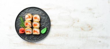 Ton balığı ve havyarlı suşi. Suşi siyah taştan bir tabakta. Üst görünüm.