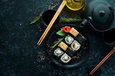 Geleneksel suşi - Siyah ve beyaz, yengeç, peynir ve bitkilerle. Japon mutfağı. Üst görünüm.