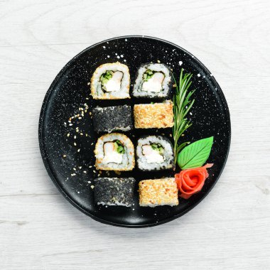 Geleneksel suşi - Siyah ve beyaz, yengeç, peynir ve bitkilerle. Japon mutfağı. Üst görünüm.