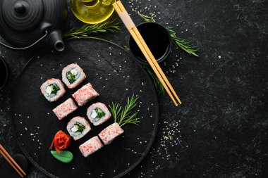 Yengeç çubuklu Japon suşisi, peynir, soğan ve salatalık. Asya Diyet Yemeği. Üst görünüm.