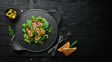 Siyah tabakta patlıcan salatası, ıspanak ve lahana. Vejetaryen yemeği. Üst Manzara. Kırsal biçim.