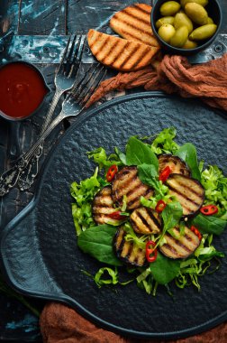 Siyah tabakta patlıcan salatası, ıspanak ve lahana. Vejetaryen yemeği. Üst Manzara. Kırsal biçim.