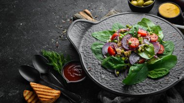 Ispanak, kinoa, domates ve sebzeden oluşan sağlıklı bir vegan salatası. Üst Manzara. Kırsal biçim.