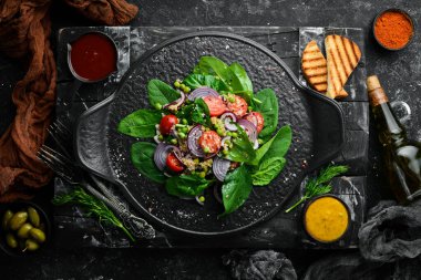 Ispanak, kinoa, domates ve sebzeden oluşan sağlıklı bir vegan salatası. Üst Manzara. Kırsal biçim.