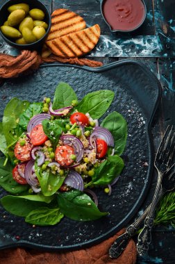 Ispanak, kinoa, domates ve sebzeden oluşan sağlıklı bir vegan salatası. Üst Manzara. Kırsal biçim.