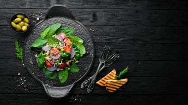 Ispanak, kinoa, domates ve sebzeden oluşan sağlıklı bir vegan salatası. Üst Manzara. Kırsal biçim.