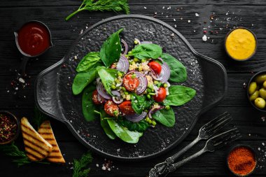 Ispanak, kinoa, domates ve sebzeden oluşan sağlıklı bir vegan salatası. Üst Manzara. Kırsal biçim.