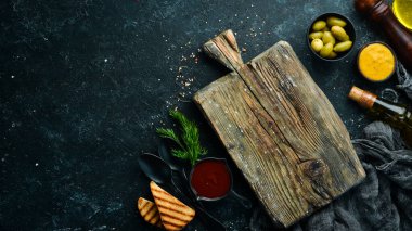Aşçılığın arka planı. Bir çift baharat ve taze sebze. Üst Manzara. Metnin için boş yer. Siyah taştan bir arka planda.