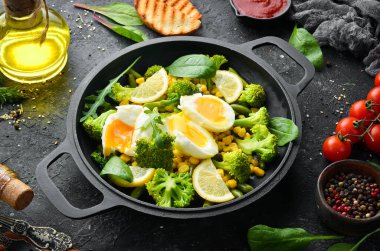 Diyet yemek. Kızartma tavasında haşlanmış sebze ve haşlanmış yumurta. Kırsal tarzda. Üst Manzara. Metnin için boş yer.