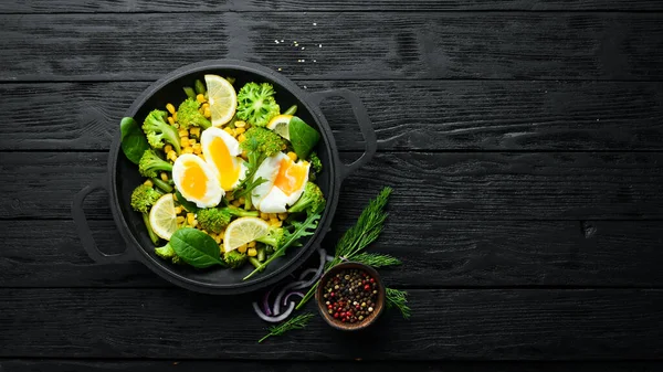 Diet food. Boiled vegetables and boiled egg in a frying pan. Rustic style. Top view. Free space for your text.