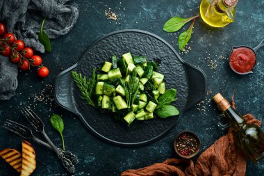 Salatalıklı vejetaryen salatası ve siyah tabakta dereotu. Kırsal tarzda. Üst Manzara. Metnin için boş yer.