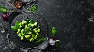 Salatalıklı vejetaryen salatası ve siyah tabakta dereotu. Kırsal tarzda. Üst Manzara. Metnin için boş yer.