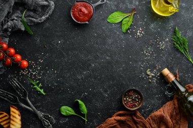 Siyah taş gıda arka planı. Sebze ve baharatlar eski siyah masada..