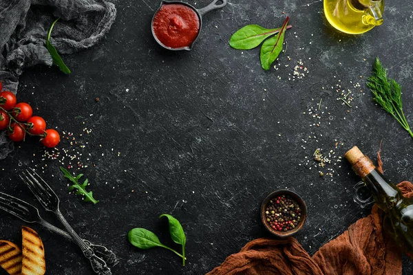 Siyah taş gıda arka planı. Sebze ve baharatlar eski siyah masada..