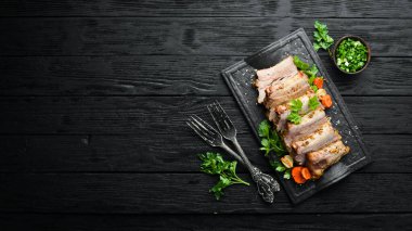 Siyah taş tabakta fırında domuz pirzolası, hardal ve baharat. Üst Manzara. Metin için boş alan.