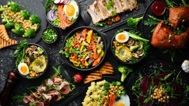 Yiyecek: Et yemekleri, sebzeler ve siyah taş zemin üzerinde deniz ürünleri. Üst Manzara. Metin için boş alan.