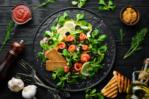 Ensalada Fresca Con Salmón Aceitunas Plato Negro Vista Superior Espacio —  Fotos de Stock