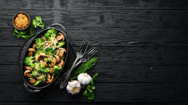 Fırında mantar ve siyah tavada peynirli brokoli. Üst Manzara. Metnin için boş yer. Kırsal biçim.