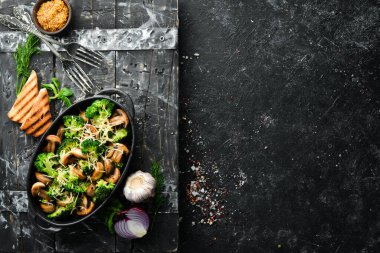 Fırında mantar ve siyah tavada peynirli brokoli. Üst Manzara. Metnin için boş yer. Kırsal biçim.