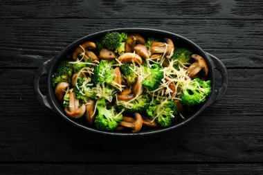 Fırında mantar ve siyah tavada peynirli brokoli. Üst Manzara. Metnin için boş yer. Kırsal biçim.