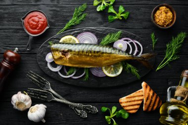 Siyah tabakta soğan ve limonlu füme balık uskumrusu. Üst Manzara. Metnin için boş yer. Kırsal biçim.